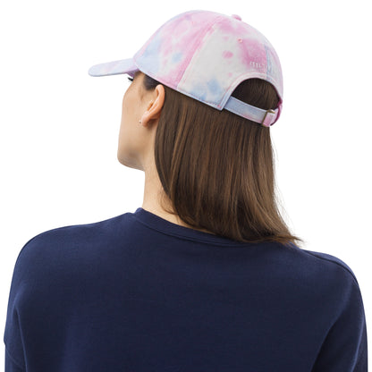 Woman showing BEET tie dye baseball cap featuring vibrant, multi-colored patterns with the BEET logo on the front.